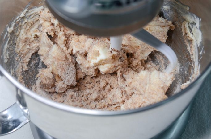 using a mixer to combine ingredients for cranberry cookies
