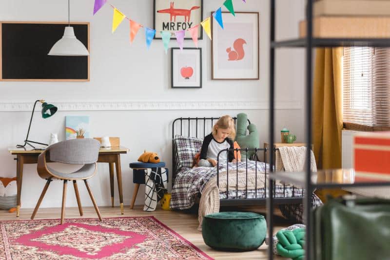 child sitting on bed in colorful bedroom