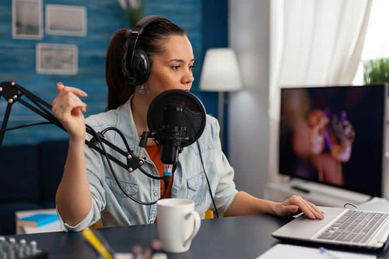 female podcaster with large microphone